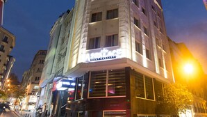 Un hotel con una facciata moderna, ampie finestre e un cartello illuminato ben visibile.