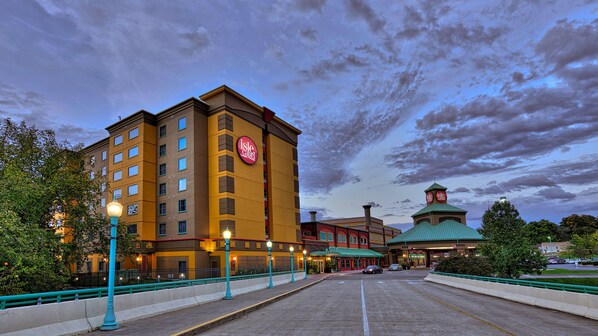 A hotel with a prominent Isle Casino sign, a large building with multiple floors, and a green-roofed structure in the background.