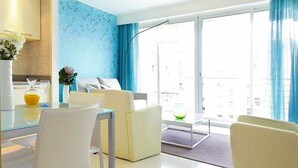 Una sala moderna con comedor, ventanas amplias y vista a la ciudad.