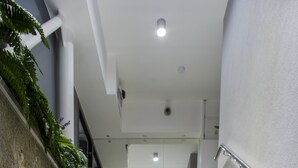 Un escalier muni d’une rampe, menant à un palier avec une porte.