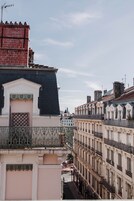 Una hilera de edificios históricos con arquitectura clásica europea, que presentan balcones ornamentados y fachadas detalladas.