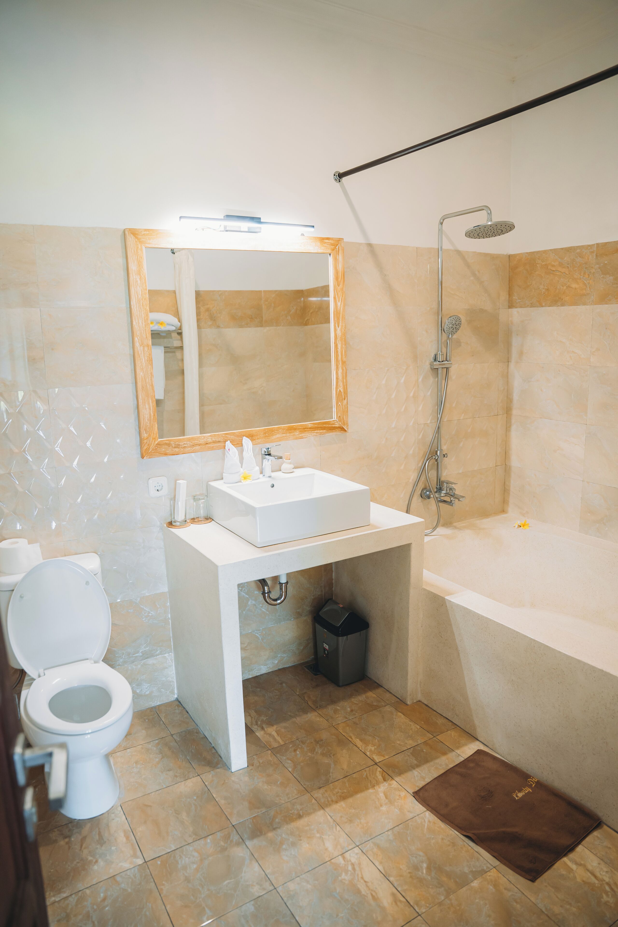 Un baño con lavamanos, espejo, inodoro y ducha.