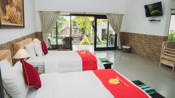 A hotel room with two beds, a TV, and a view of the garden.