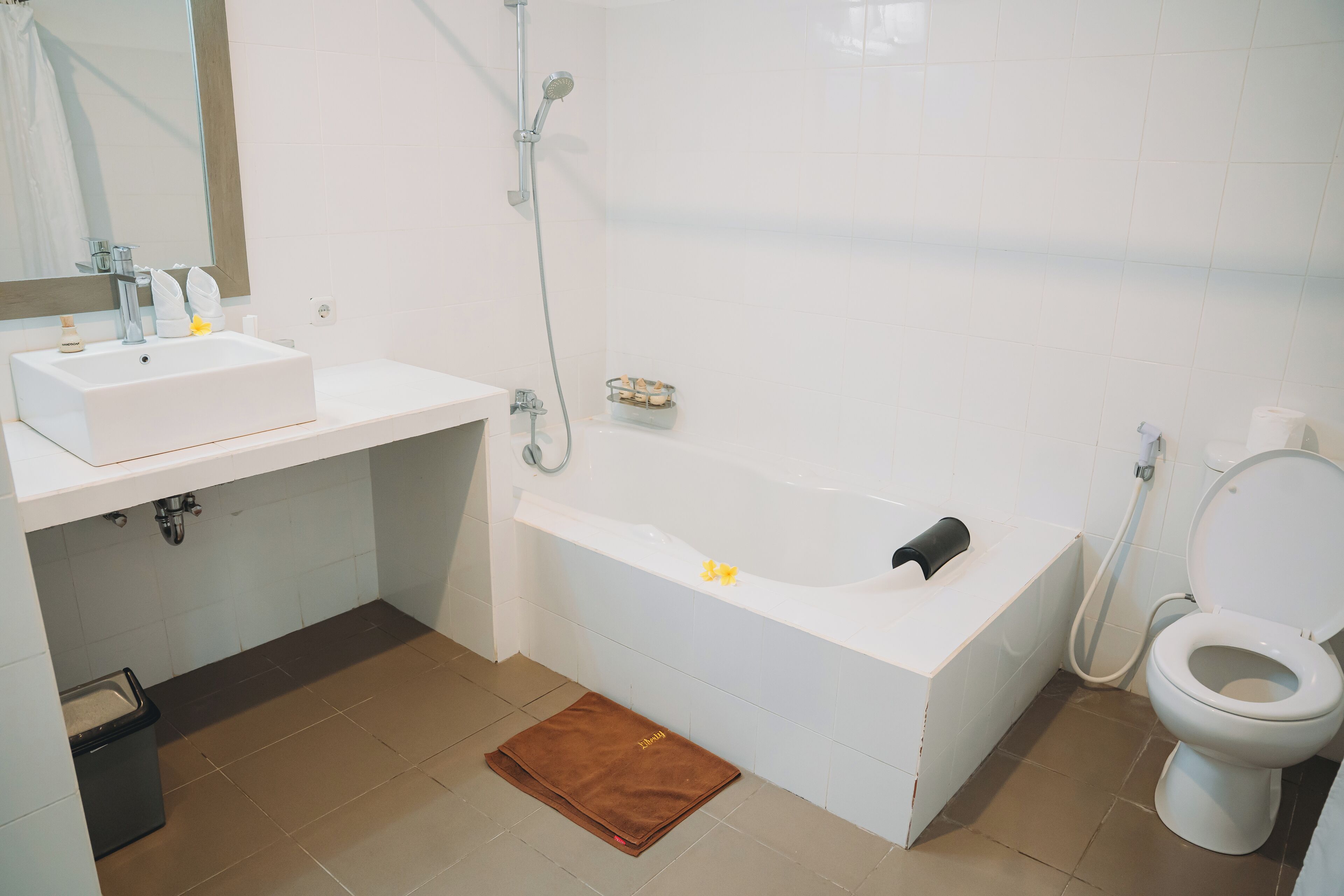 Een moderne badkamer met een witte wastafel, een bad en een toilet.