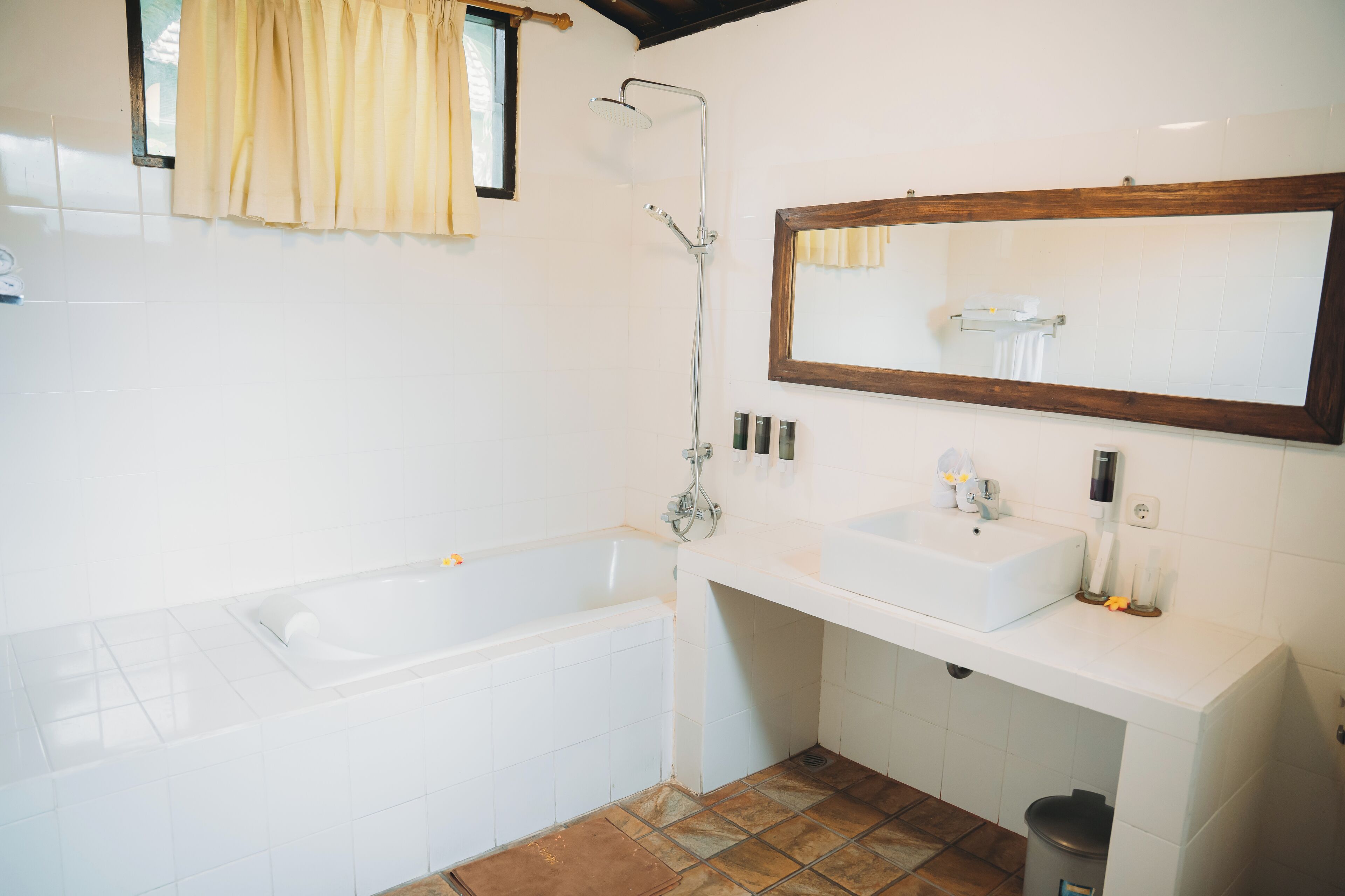 Un baño con bañera, lavabo, espejo y ducha.