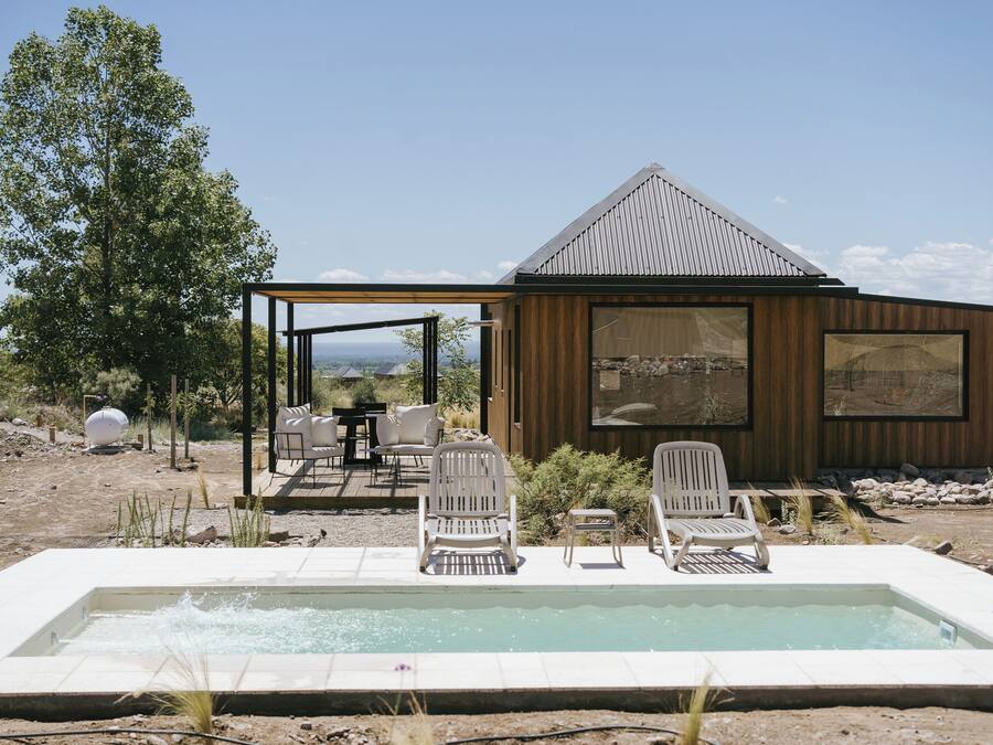 Un bâtiment moderne doté d’une piscine, d’un espace extérieur aménagé et offrant une vue sur le paysage.