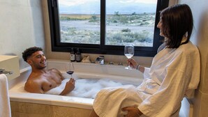 A man and a woman in a bathtub with a view of a desert landscape. - La Morada Lodge - Valle de Uco (Tunuyan)