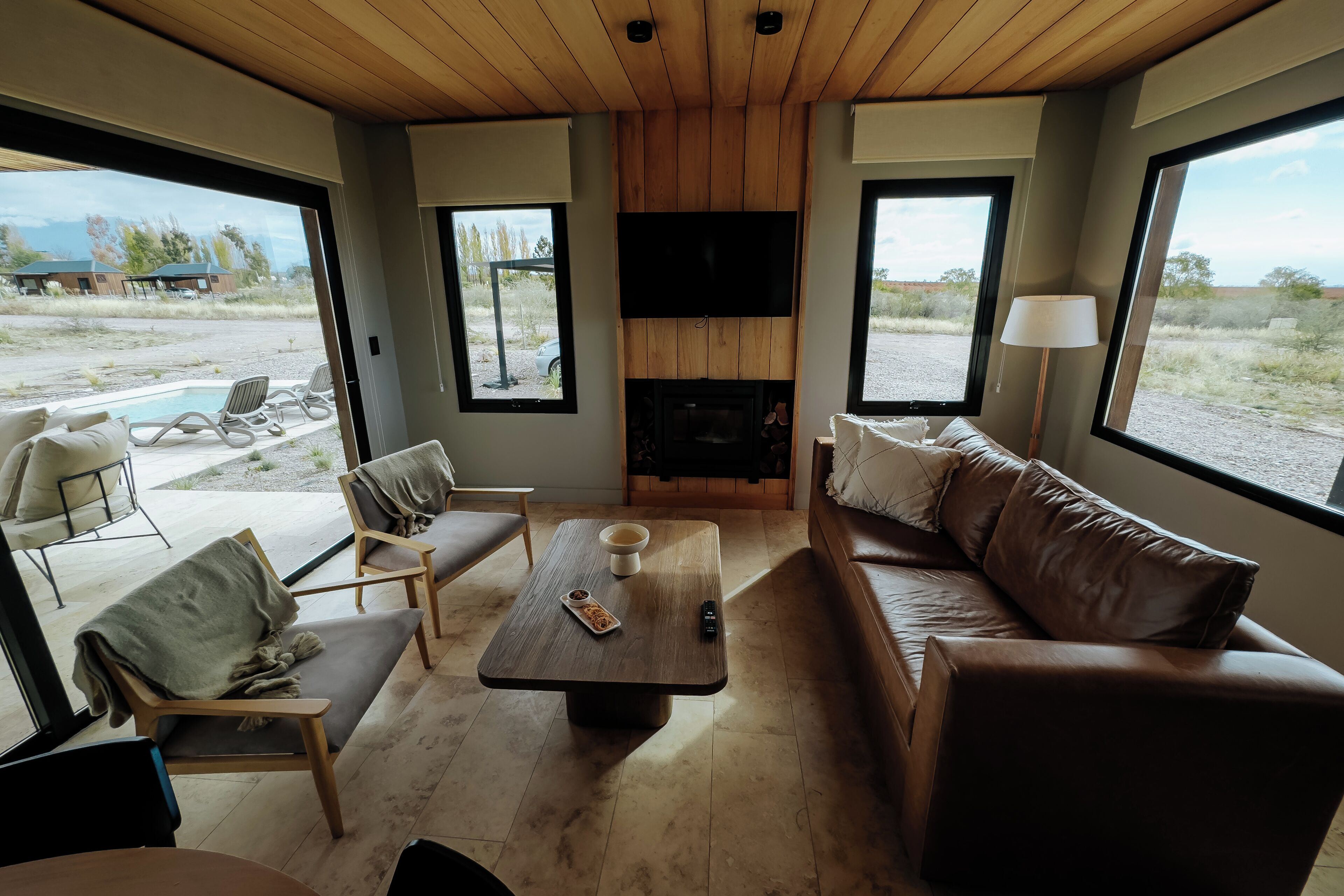 A modern living room with a fireplace, a sofa, a coffee table, and a TV.