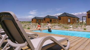 Una piscina al aire libre, sombrillas, tumbonas