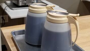 Two gray water bottles with beige lids on a metal tray.