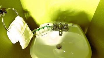 A bathroom sink with a towel hanging on a metal rack.
