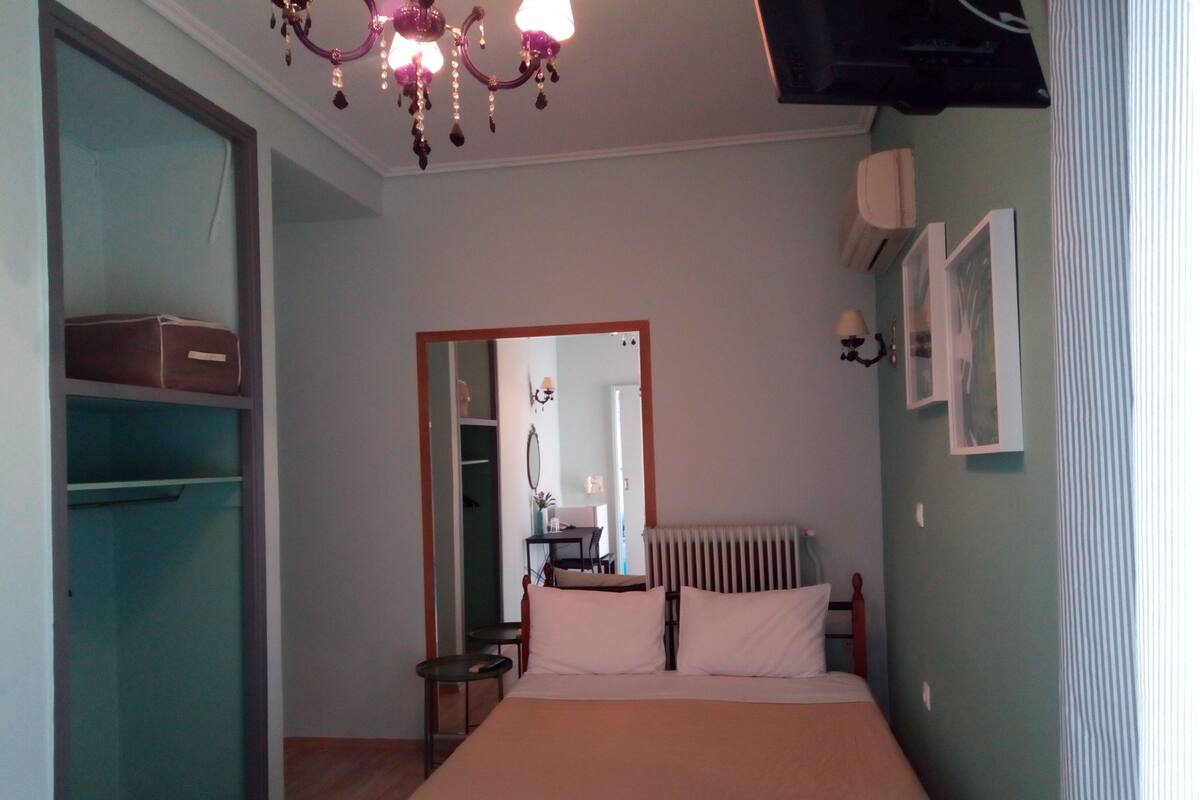 Ein Schlafzimmer mit Bett, Schminktisch, Spiegel, Heizkörper und einer Chandelier.