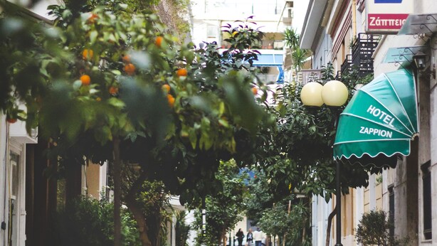 Una calle estrecha bordeada de edificios, incluyendo un hotel con un letrero que dice "HOTEL ZAPPION".
