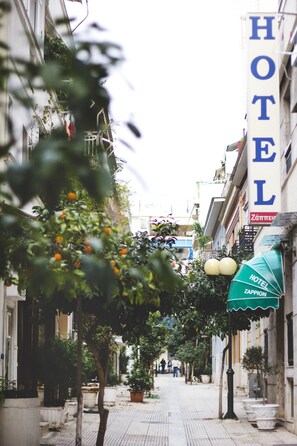A narrow street lined with buildings, including a hotel with a sign that reads "HOTEL ZAPPION." - Zappion Hotel (Athens)