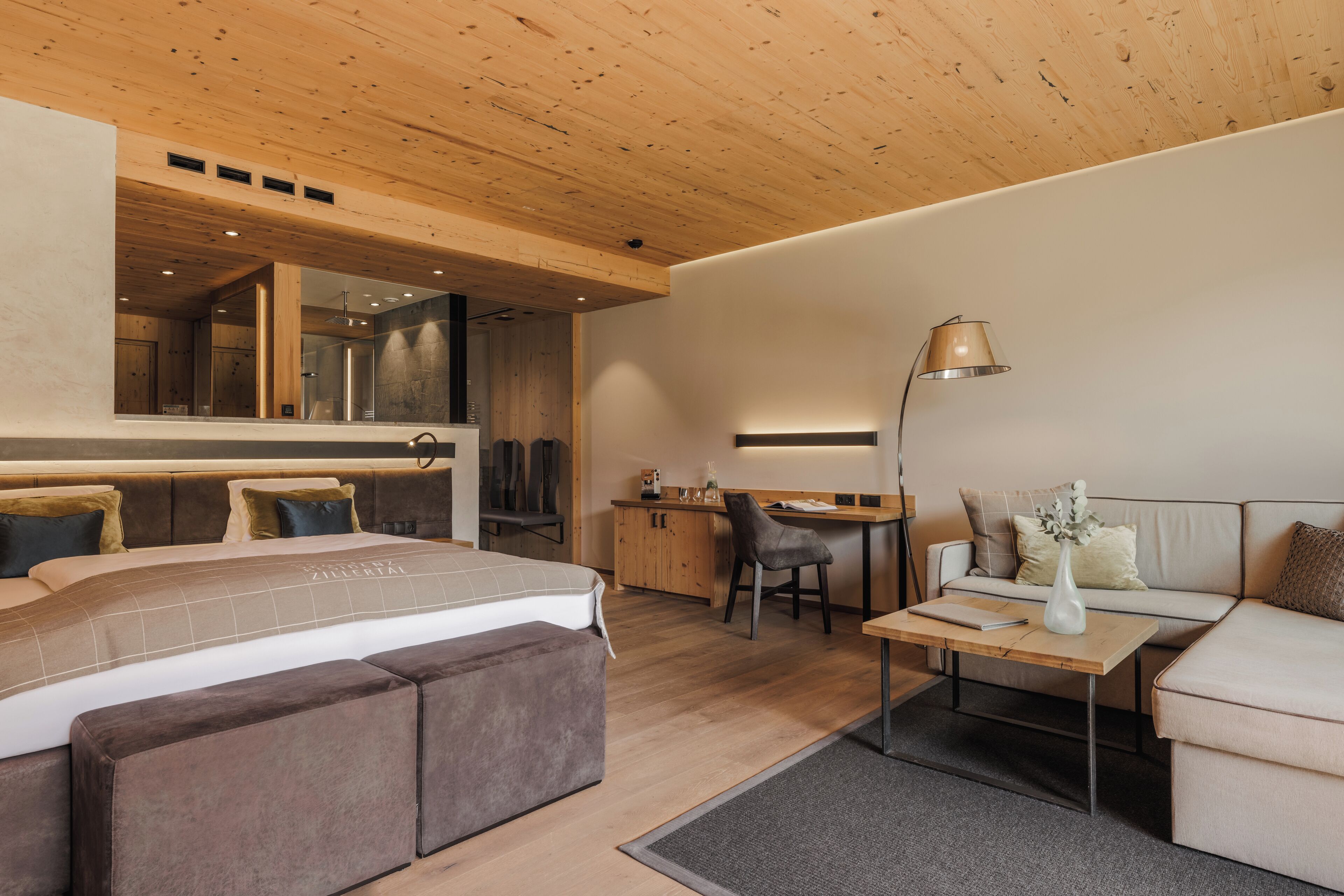 Un dormitorio moderno con una cama grande, un escritorio y un sofá.
