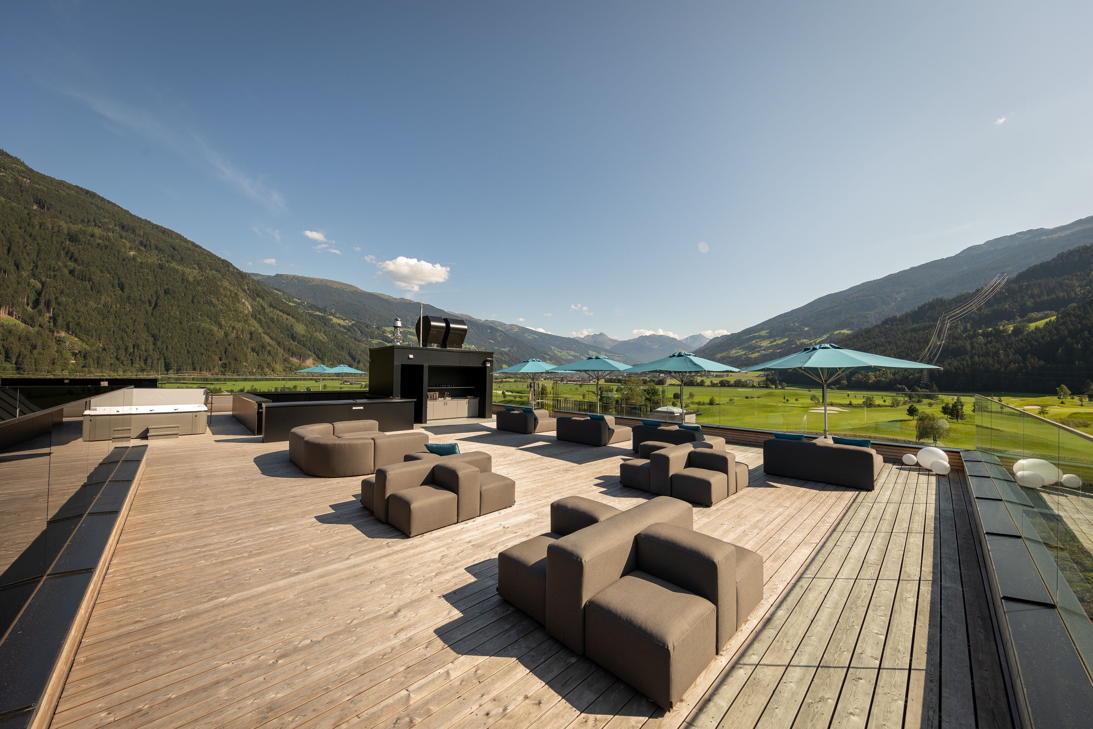 A wooden deck with outdoor seating and a view of a golf course.