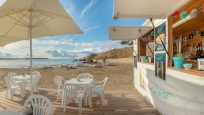 Un café frente al mar con terraza y vistas al océano.