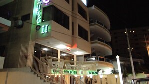 A multi-story hotel with a prominent sign, a staircase leading to the entrance, and a balcony on the second floor. - Hotel Francisco II (Salinas)