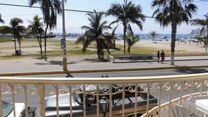 A beach view with palm trees, a road, and parked vehicles. - Hotel Francisco II (Salinas)