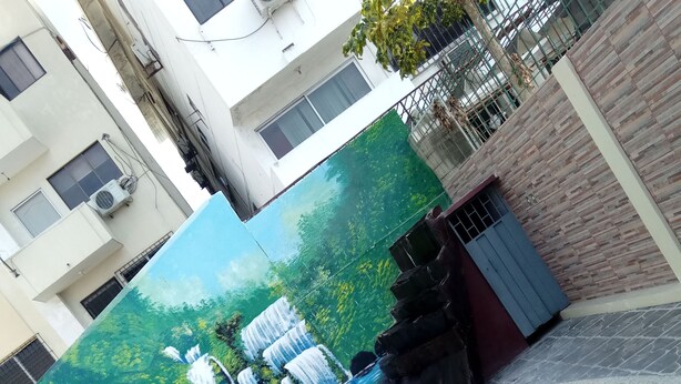 A swimming pool with a mural of waterfalls and greenery. - Hotel Francisco II (Salinas)