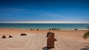 A wooden deck with geometric seating and a view of the beach and ocean.