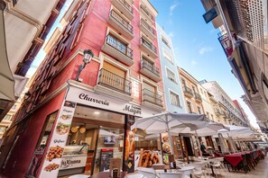 A street with outdoor seating and a bakery named 'Chaverriá'.