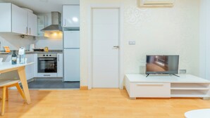 A compact living space with a kitchenette, a dining area, and a TV on a stand. - Apartamentos Globus by Be Alicante (Alicante)