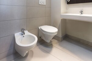 A modern bathroom with a bidet, toilet, and sink.