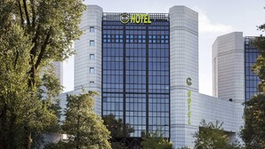 Un moderno edificio de hotel con un llamativo letrero que dice 'HOTEL' en la fachada, que presenta un diseño de ventanas tipo entramado.