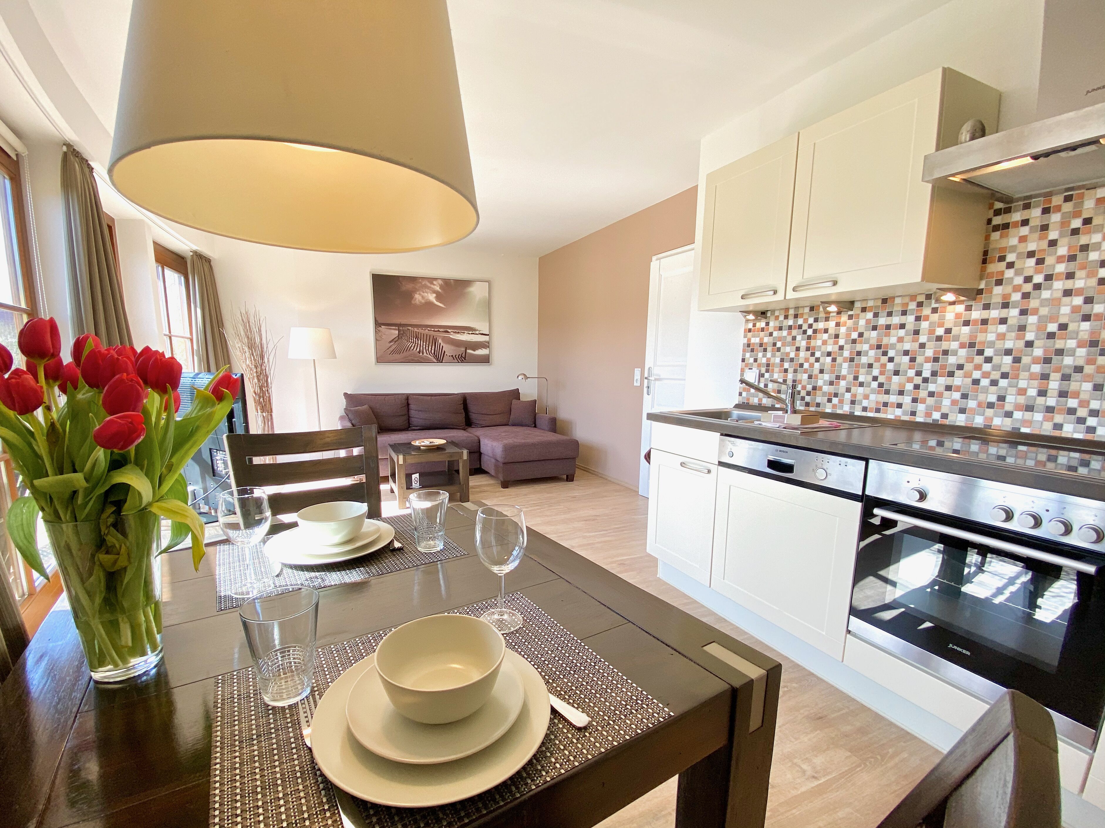 A modern kitchen with white cabinets, a tiled backsplash, and a built-in oven.