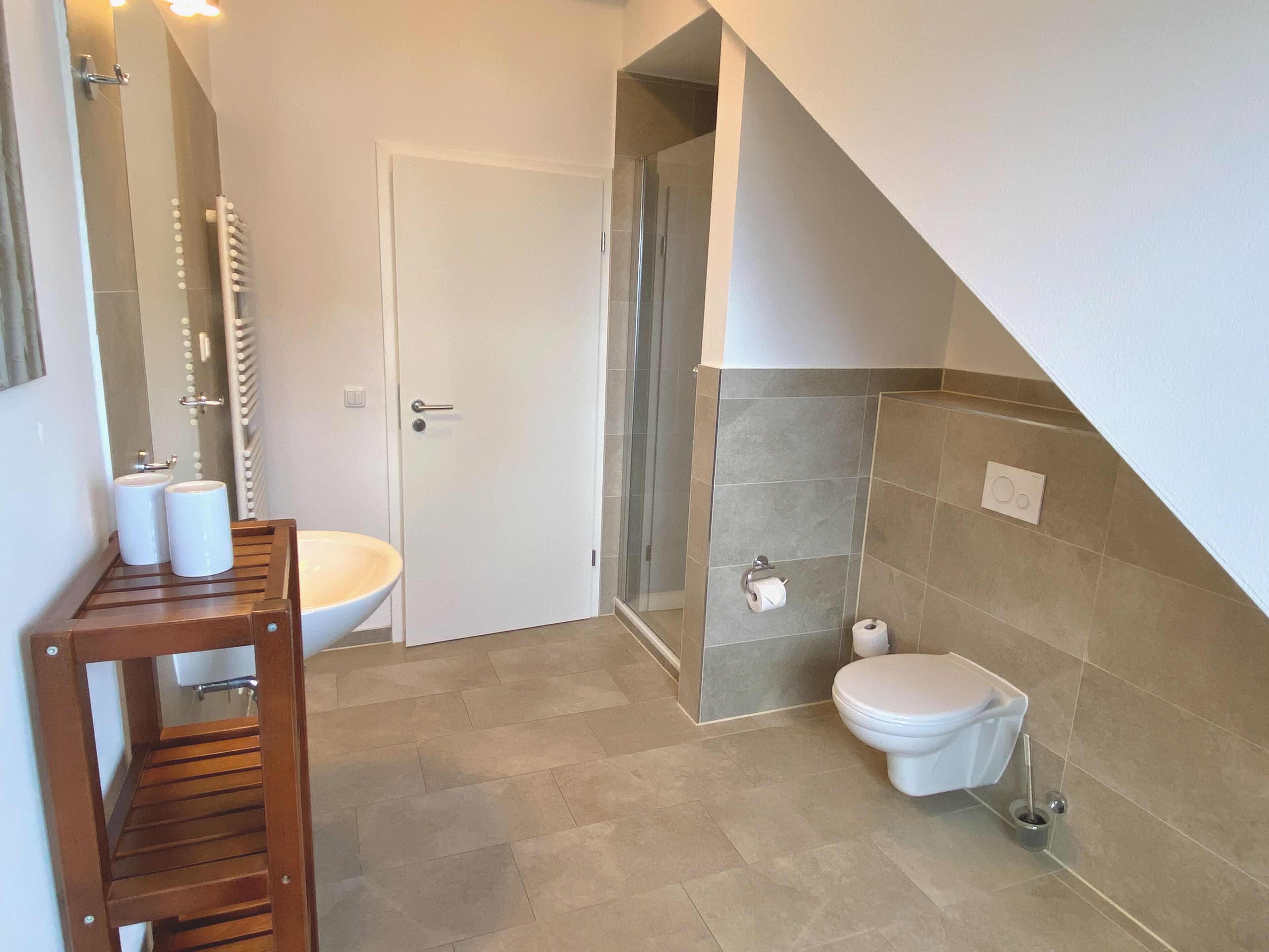 A bathroom with a sink, toilet, and shower area.