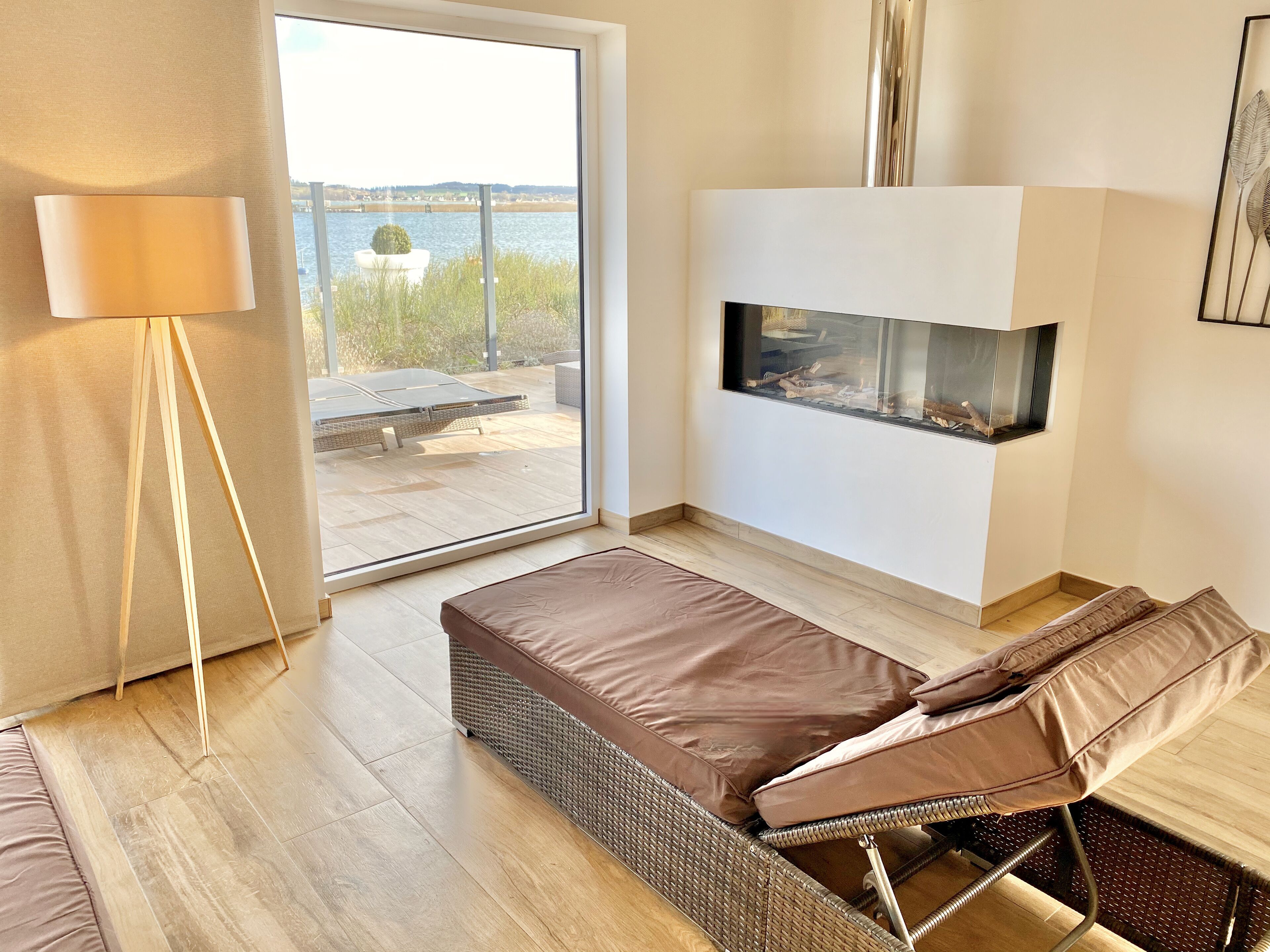 Een moderne woonkamer met een groot raam, een open haard en een bank.