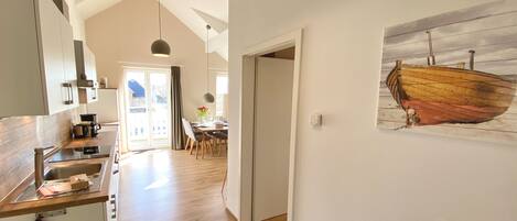 A modern kitchen with wooden countertops and a dining area with a table and chairs.