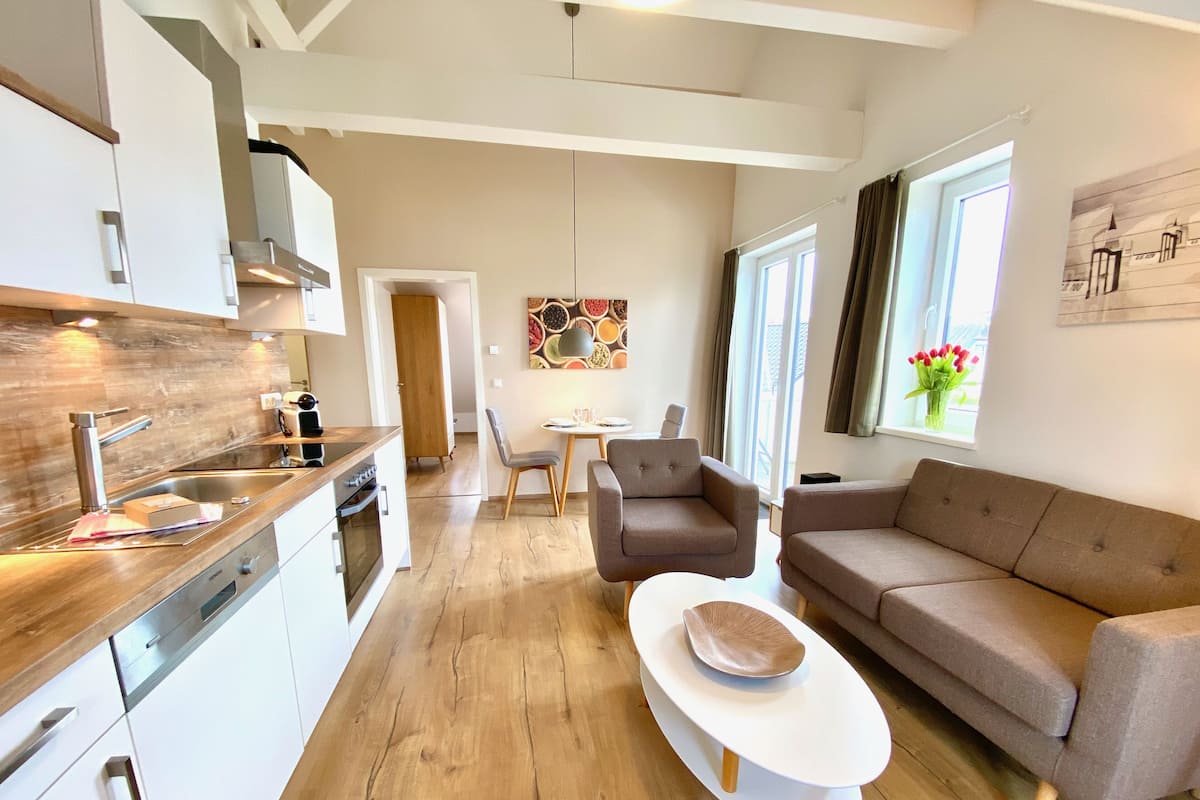 A modern apartment with a kitchen, dining area, and living room.
