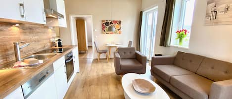 A modern apartment with a kitchen, dining area, and living room.
