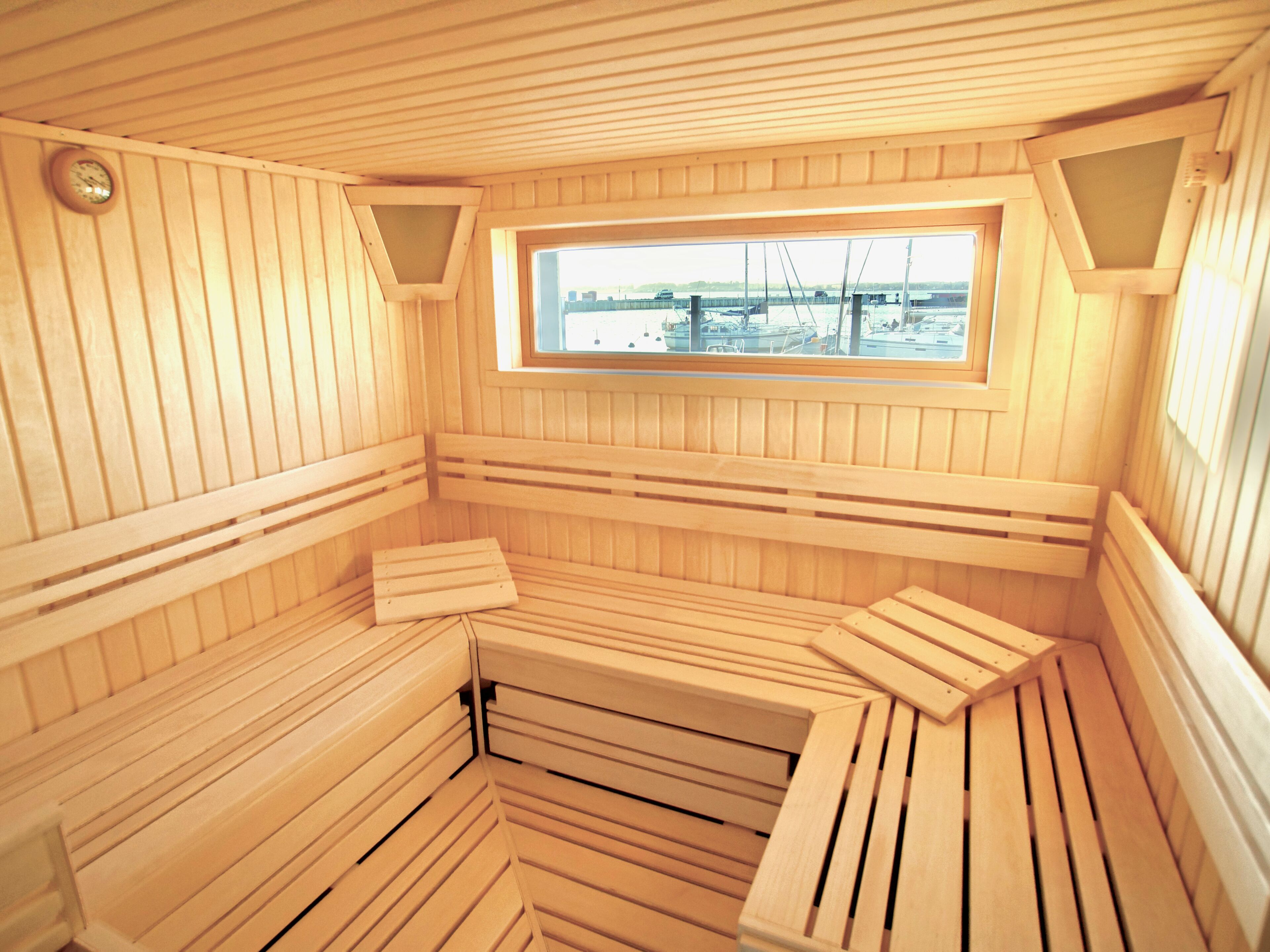 Una sauna con panche in legno e un lucernario.