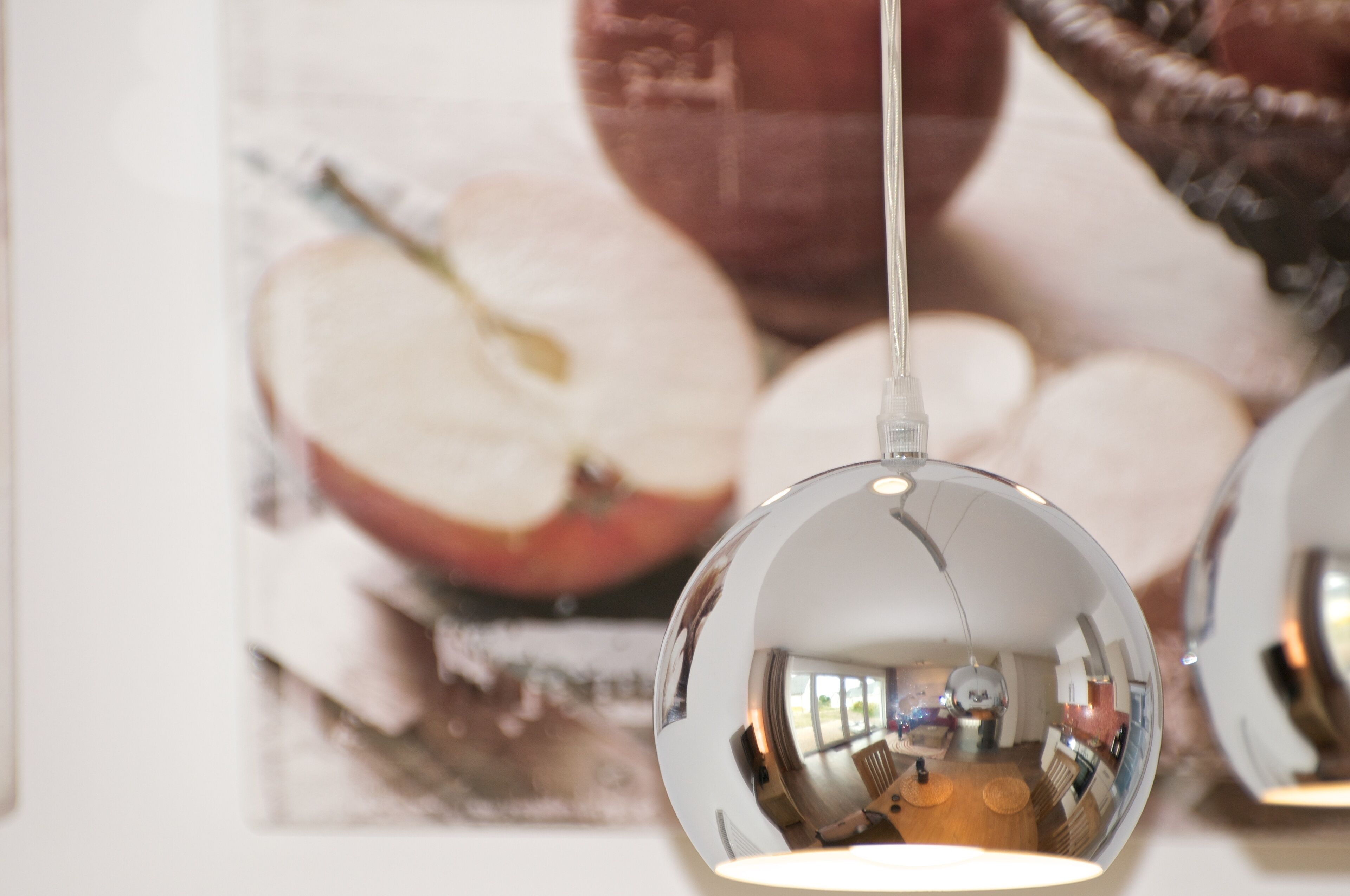 A spherical mirror hanging from the ceiling reflecting a room interior.