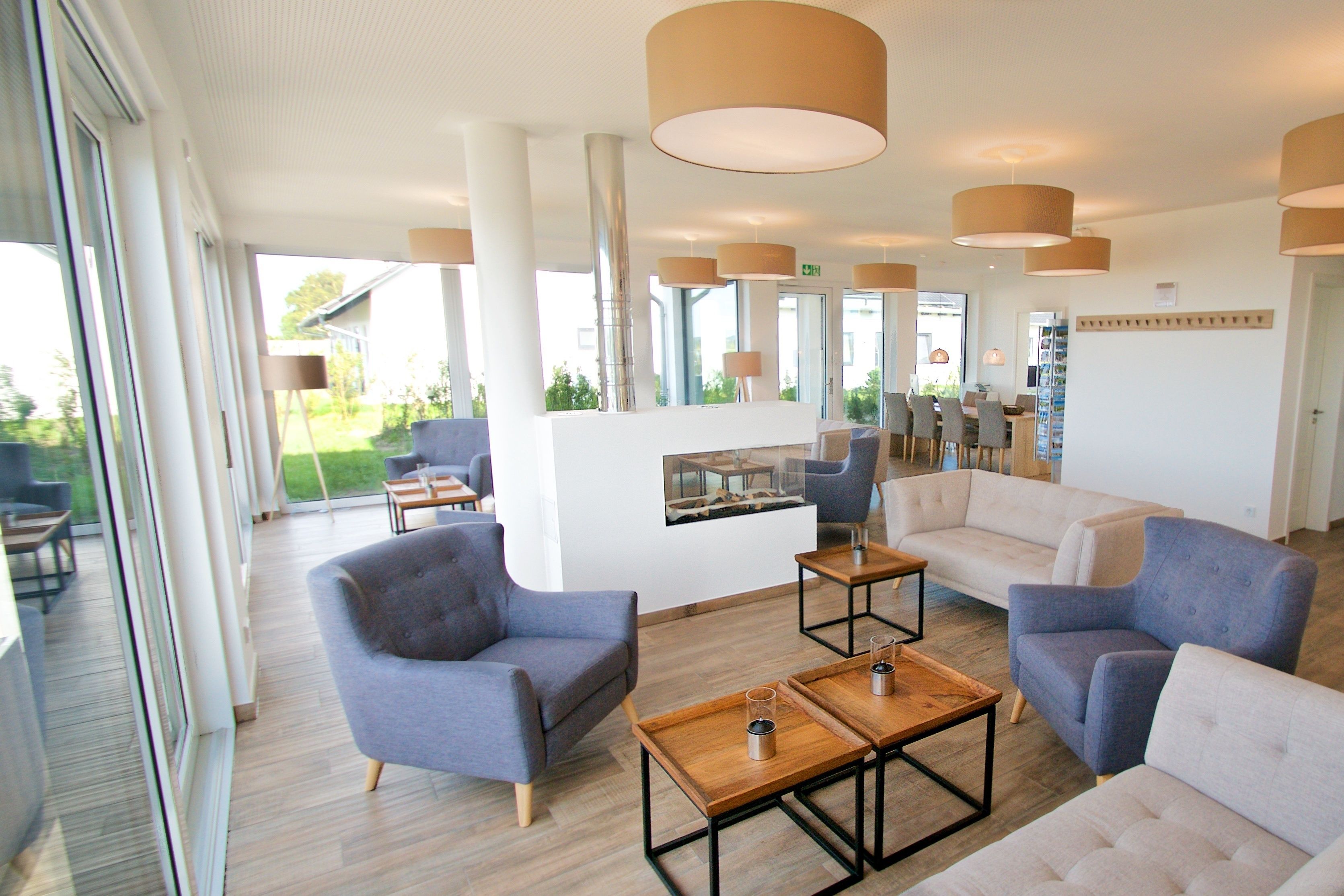 Un espace de détente moderne, doté de sièges, de tables et de grandes fenêtres.