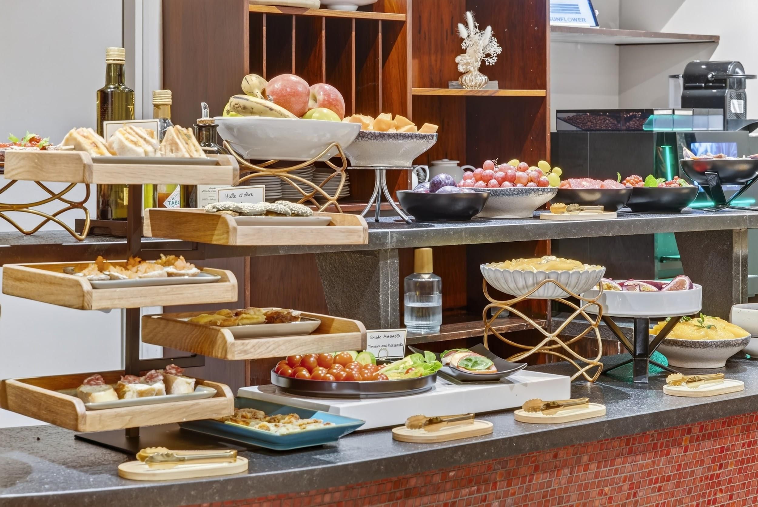 A buffet setup with various food items and serving utensils.