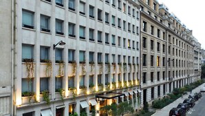 A multi-story hotel with a uniform facade, large windows, and outdoor lighting. - The One Alma Paris (Paris)