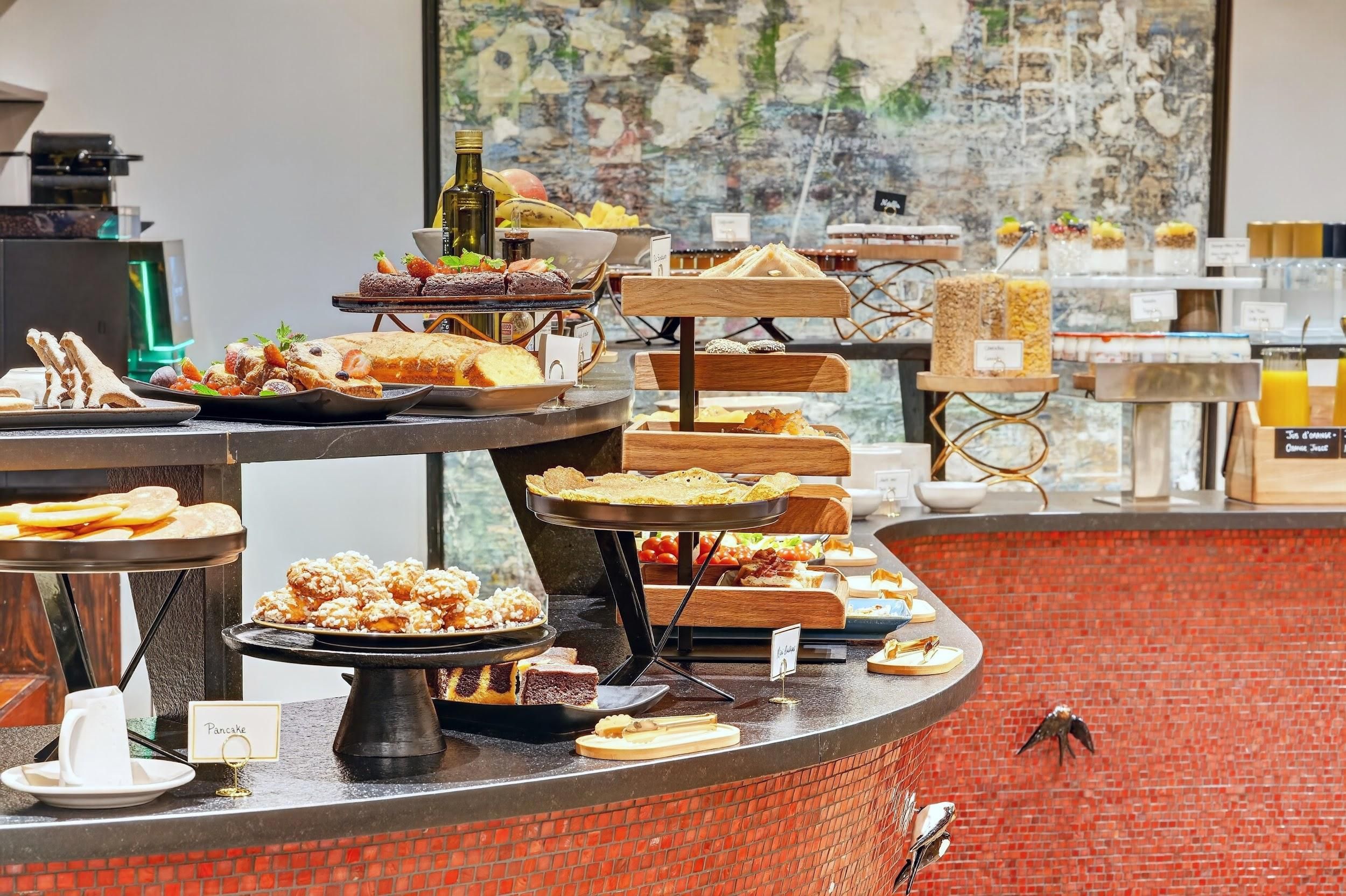 Un buffet proposant une variété de plats, avec un mur de briques en arrière-plan.