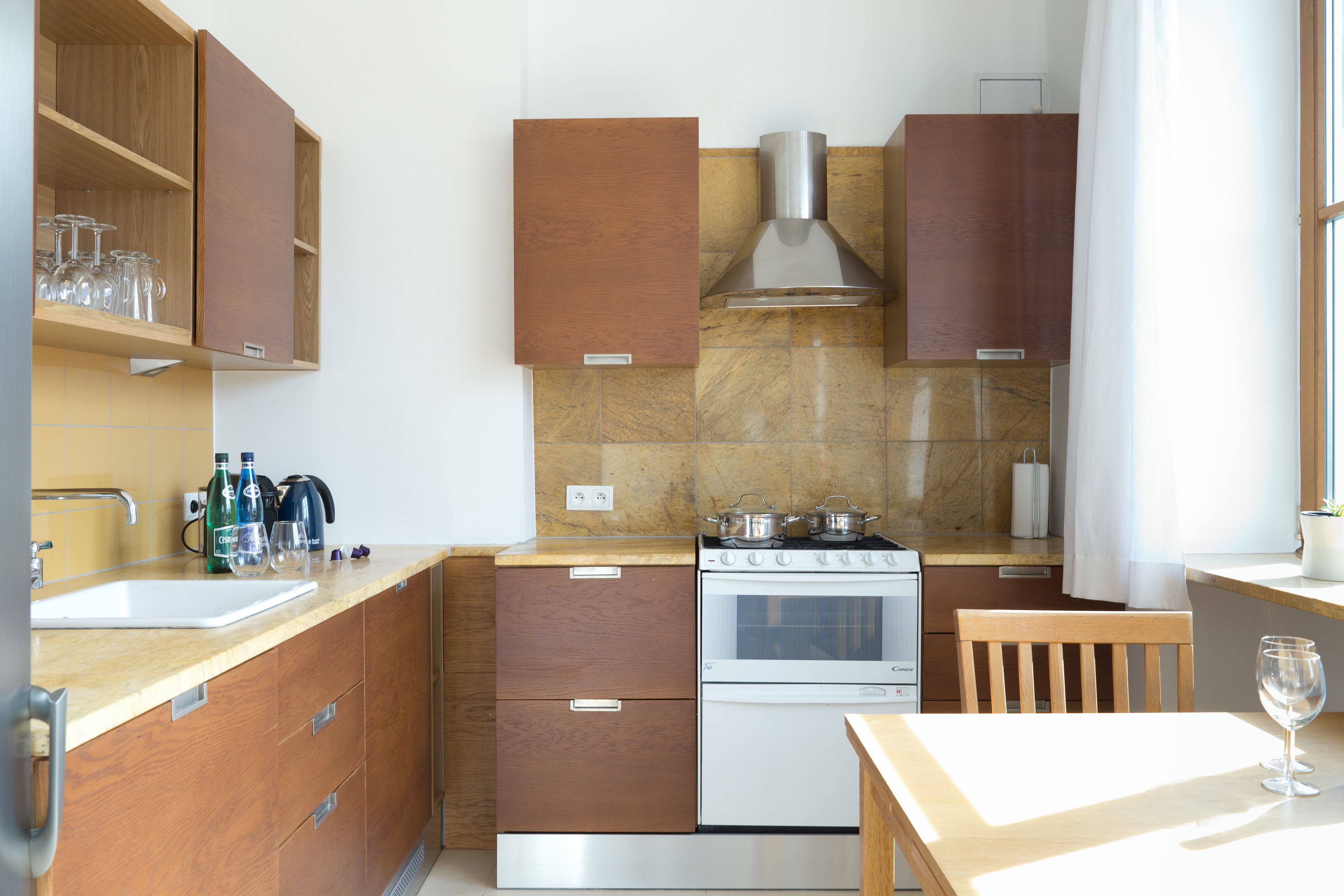 A kitchen with wooden cabinets, a stove, and a sink.
