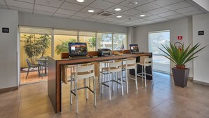 A reception area with a wooden counter, white chairs, and a potted plant. - City Express by Marriott Salamanca (Salamanca)