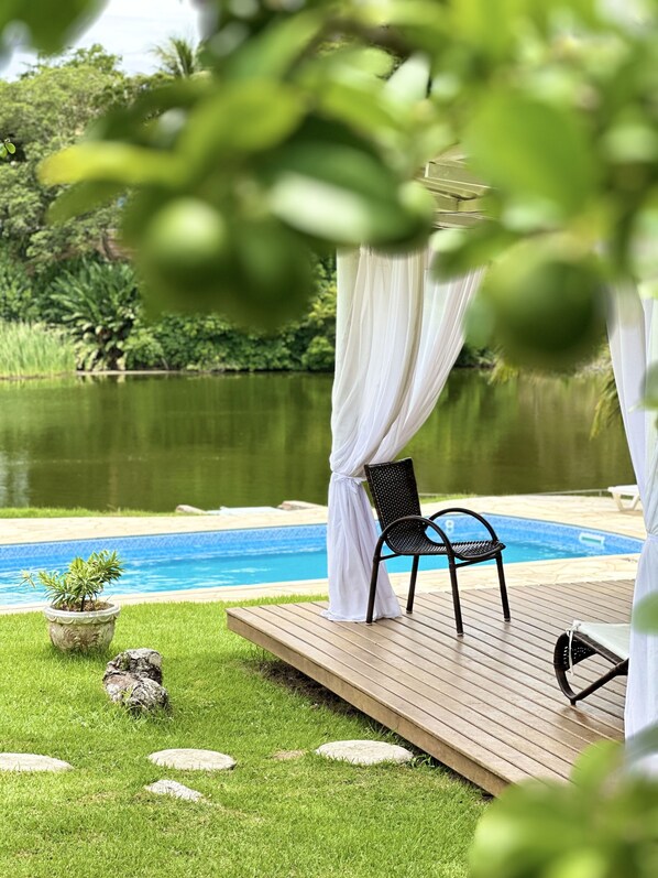 Una piscina al aire libre, sillones reclinables de piscina