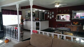 A hotel lobby with a reception desk, a small Christmas tree, a dining area with a round table and chairs, and a white railing. - Willard Country Inn (Willard)