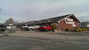 A Willard Country Inn with a parking lot containing several vehicles. - Willard Country Inn (Willard)
