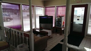 A room with a television, a vending machine, and a door marked "EXIT". - Willard Country Inn (Willard)