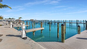 A marina with boats docked, a wooden pier, and a clear blue sky. - 1 Island Hideaway in the Keys (Marathon)