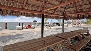 A beachside pavilion with wooden benches and a thatched roof. - 1 Island Hideaway in the Keys (Marathon)