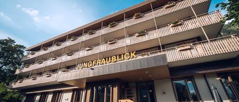 A multi-story building with balconies, a staircase, and outdoor seating.